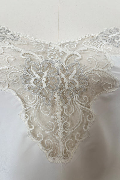 Detail view of 1970s vintage white polyester challis and floral lace faux pearl embellished lingerie camisole top by Christian Dior, size small to medium.  Showing the floral lace neckline and faux pearl details.