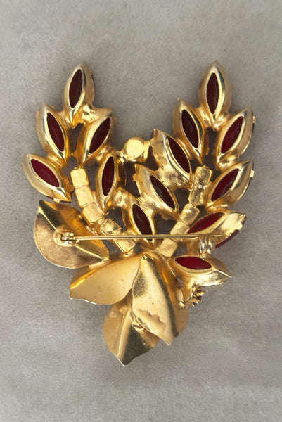 Vertical back view of 1950s vintage iridescent crimson red rhinestone and gold tone floral brooch.