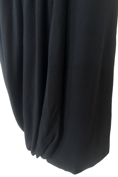 Detail view of 1940s vintage black wool crew neck, 3/4 sleeve, drop waist dress with asymmetrical gathered front draped wrap skirt, size extra small to small. Showing the asymmetrical draping at the skirt hem.