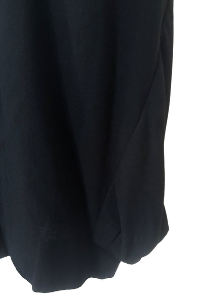 Detail view of 1940s vintage black wool crew neck, 3/4 sleeve, drop waist dress with asymmetrical gathered front draped wrap skirt, size extra small to small. Showing the asymmetrical draping at the skirt hem.