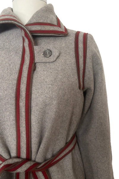 Detail view of 1960s vintage heavy gray and rust tie waist wool coat by Carol Cohen for Braefair, size medium to large. Showing the rust wool striping at the collar, shoulders, front placket, and tie, as well as the off center gray plastic button.