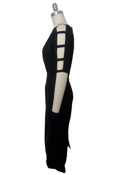 Side view of 1950s vintage black boat neck, raglan open sleeve wiggle dress, size small to medium. Showing the open ladder pattern sleeves.