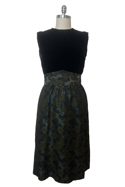 Front view of 1950s vintage black velvet crew neck, sleeveless, green floral brocade pencil skirt cocktail dress, with beaded belt, size medium to large.