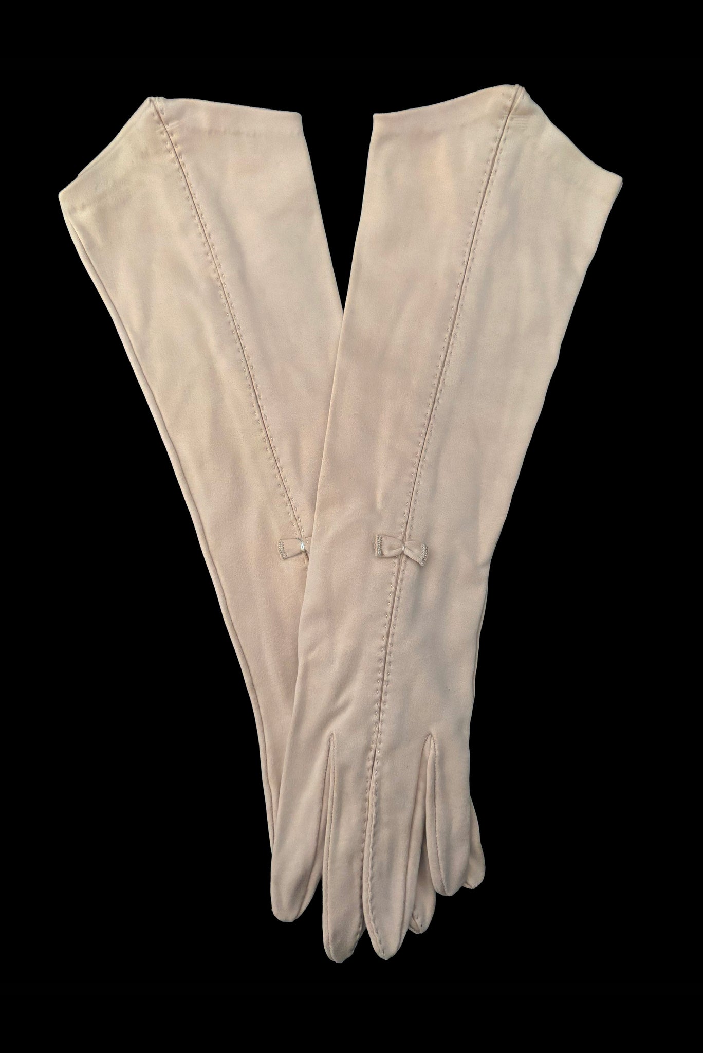 Vertical pair view of 1950s vintage Below elbow pointed cuff beige Sea Island cotton gloves, by Christian Dior, size 7.5.