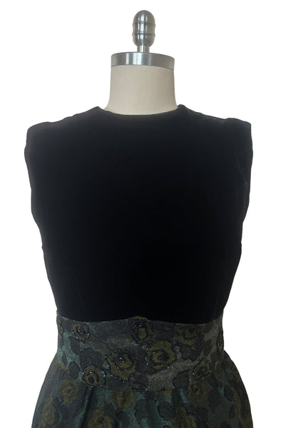 Bodice front view of 1950s vintage black velvet crew neck, sleeveless, green floral brocade pencil skirt cocktail dress, with beaded belt, size medium to large. Showing the pointed matching belt embellished with iridescent glass seed beads.