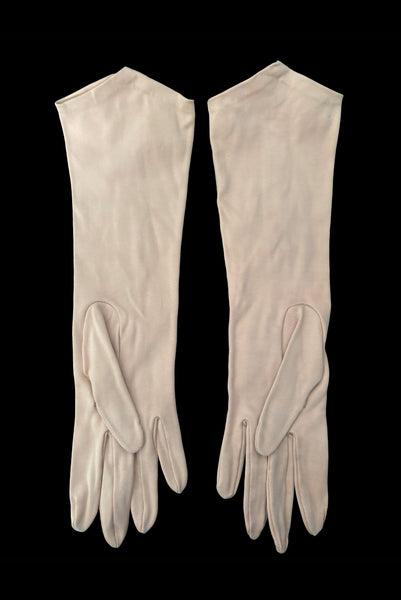 Vertical back view of 1950s vintage Below elbow pointed cuff beige Sea Island cotton gloves, by Christian Dior, size 7.5. Showing a tiny spot on the right glove near the cuff.