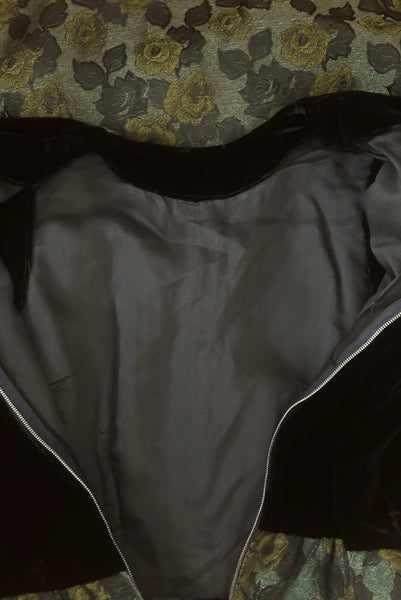 Detail view of 1950s vintage black velvet crew neck, sleeveless, green floral brocade pencil skirt cocktail dress, with beaded belt, size medium to large. Showing the black voile underlining and metal zipper.