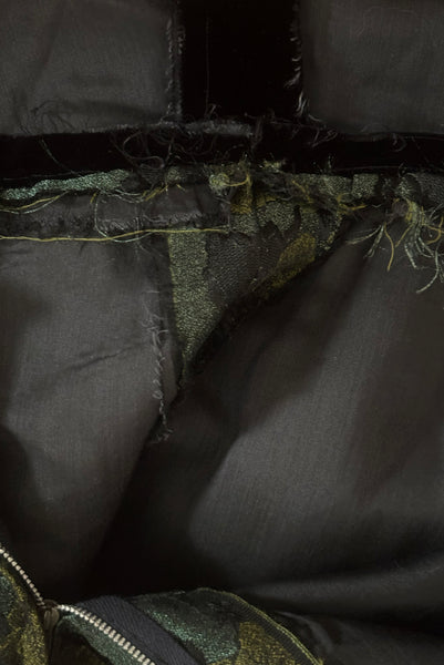Interior detail view of 1950s vintage black velvet crew neck, sleeveless, green floral brocade pencil skirt cocktail dress, with beaded belt, size medium to large. Showing the black voile underlining and seam allowance.