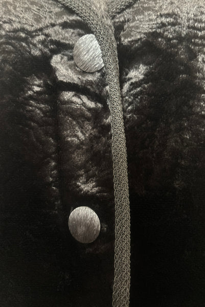 Detail view of 1950s vintage black faux Persian lamb embossed velvet jacket, by Specialty House Fashion, size small to medium. Showing the black plastic buttons.