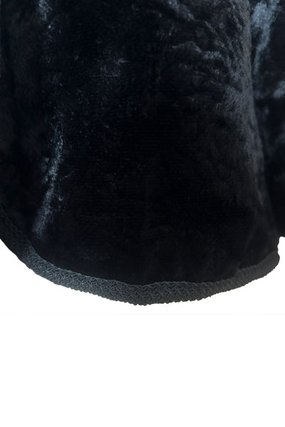 Detail view of 1950s vintage black faux Persian lamb embossed velvet jacket, by Specialty House Fashion, size small to medium. Showing the braid trimmed hem.