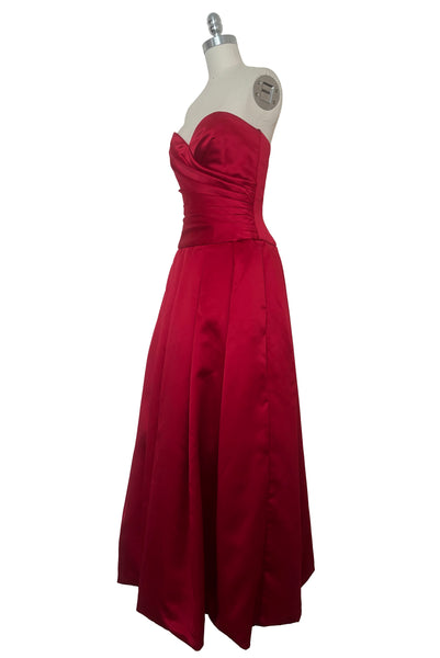 3/4 view of 1990s strapless sweetheart pleated bodice full pleated red peau de soie satin evening gown by AJ Bari, size extra small to small.