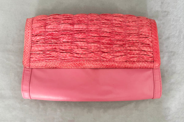 Horizontal front view of 1980s vintage pink snakeskin and leather clutch purse with detachable strap by Impo.