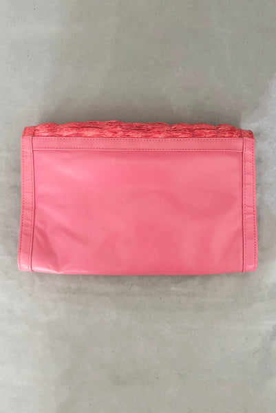 Vertical back view of 1980s vintage pink snakeskin and leather clutch purse with detachable strap by Impo.