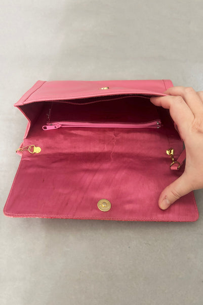 Vertical open view of 1980s vintage pink snakeskin and leather clutch purse with detachable strap by Impo. Showing the gold tone hardware, matching pink satin lining, and side pocket with zipper.