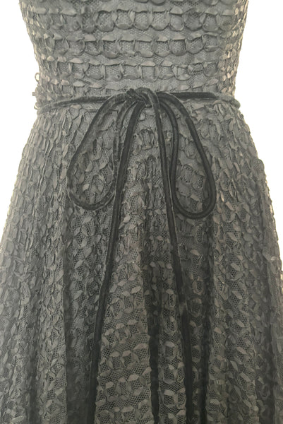 Detail view of 1950s vintage sleeveless New Look style black tulle silk ribbon dress by Dance Time, size extra small to small. Showing the black velvet cord tie belt.