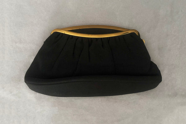 Horizontal front view of 1950s vintage black faille gold tone metal frame side clasps clutch handbag.