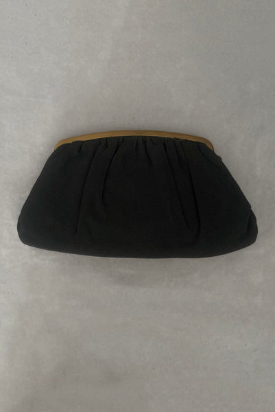 Vertical back view of 1950s vintage black faille gold tone metal frame side clasps clutch handbag.