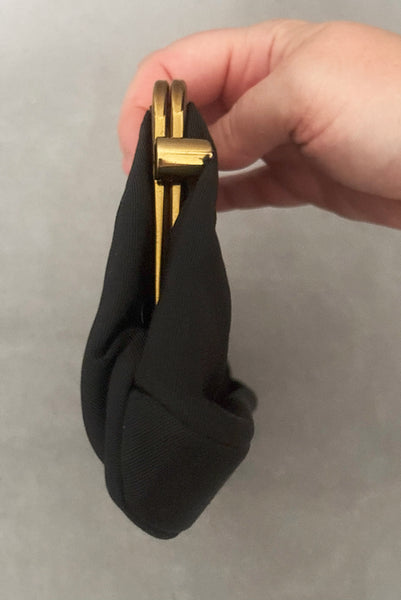 Vertical side view of 1950s vintage black faille gold tone metal frame side clasps clutch handbag.
