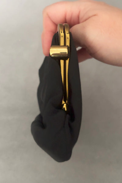 Vertical side view of 1950s vintage black faille gold tone metal frame side clasps clutch handbag.
