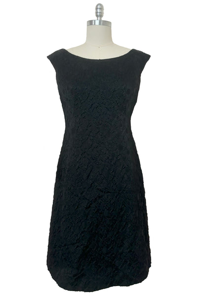 Front view of 1960s vintage black matelassé jacquard Mod cocktail dress and red satin lined wrap, size medium to large.
