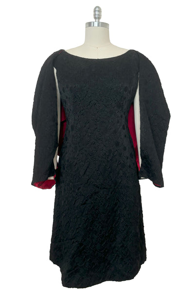 Front view of 1960s vintage black matelassé jacquard Mod cocktail dress and red satin lined wrap, size medium to large.