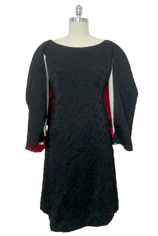 Front view of 1960s vintage black matelassé jacquard Mod cocktail dress and red satin lined wrap, size medium to large.