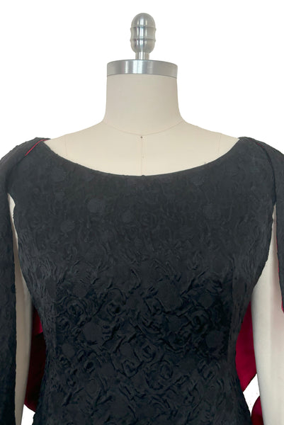 Bodice front view of 1960s vintage black matelassé jacquard Mod cocktail dress and red satin lined wrap, size medium to large.