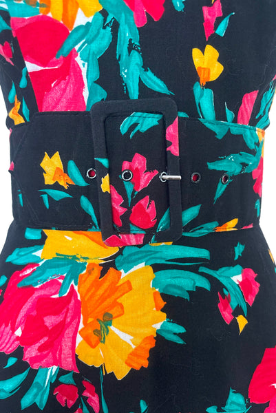 Waist front detail view of vintage 1990s black, pink, green, and yellow floral halter dress with matching belt by Concepts, extra small to small. Showing a close up of the belt and self covered buckle.