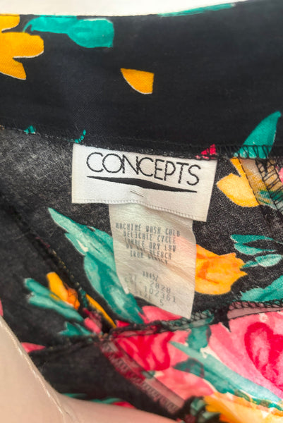 Interior detail view of vintage 1990s black, pink, green, and yellow floral halter dress with matching belt by Concepts, extra small to small. Showing the label and tag.