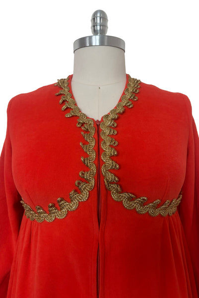 Detail view of 1960s  vintage orange fleece zip front housecoat w/ gold metallic braid by Periphery, size medium to large. Showing the curved empire waist and gold bullion trim.