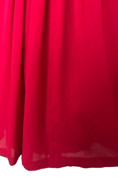 Detail view of 1960s vintage draped raspberry pink silk chiffon cocktail dress by Miss Bonwit, size extra small to small. Showing a small spot on the overskirt back.