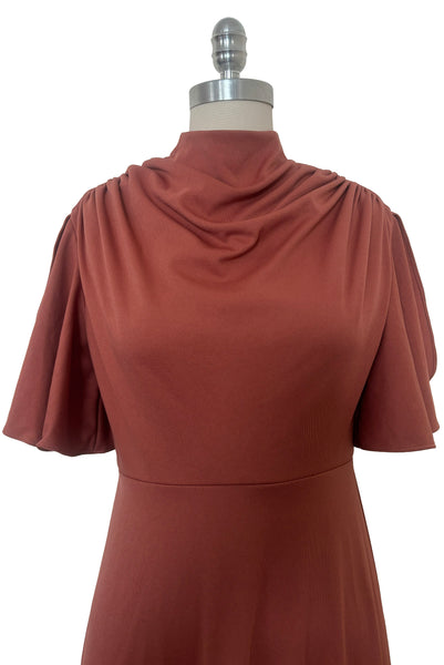 Bodice front view of 1970s vintage new with out tags terra cotta brown high neck knit maxi bridesmaids dress by Lorrie Deb, size small to medium. Showing the high cowl neckline and flutter sleeves.