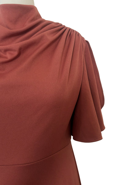Detail view of 1970s vintage new with out tags terra cotta brown high neck knit maxi bridesmaids dress by Lorrie Deb, size small to medium. Showing the high cowl neckline and flutter sleeves.
