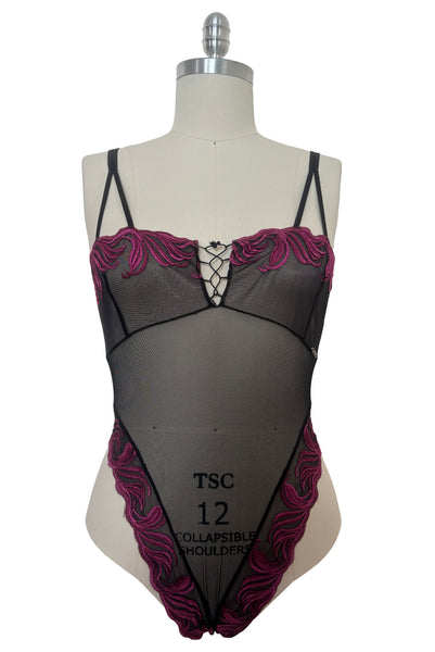 Front view of 1990s vintage black and fuchsia pink embroidered sheer mesh high cut throng bodysuit by Extreme, size medium to large.