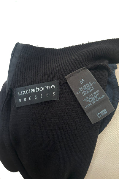 Interior detail view of 1990s black mockneck wool blend sweater dress with peplum by Liz Claiborne, medium to large. Showing the Liz Claiborne label and size m with fabric composition tag.