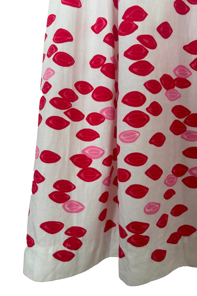 Detail of 1950s vintage red and pink lips novelty border print white cotton sleeveless, full gathered skirt dress, size extra small to small. Showing a close up of the border print hem.