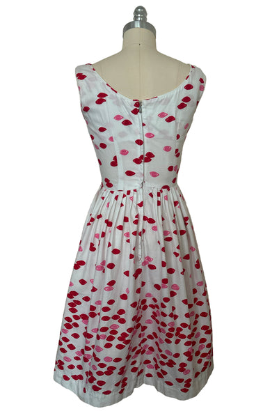 Back view of 1950s vintage red and pink lips novelty border print white cotton sleeveless, full gathered skirt dress, size extra small to small.