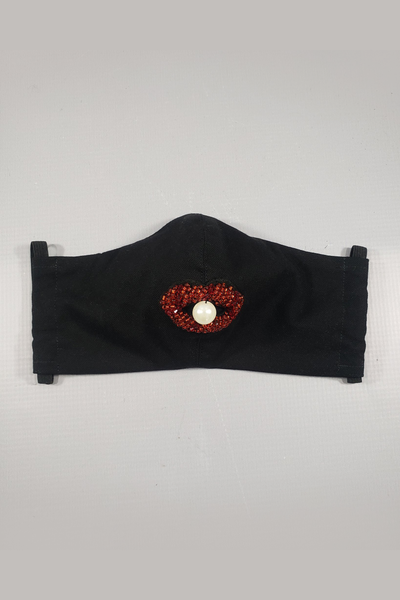 The Leslie Courreges Elsa Face Mask features a glass bead and faux pearl embellishment for a surreal addition to a practical black cotton face mask.