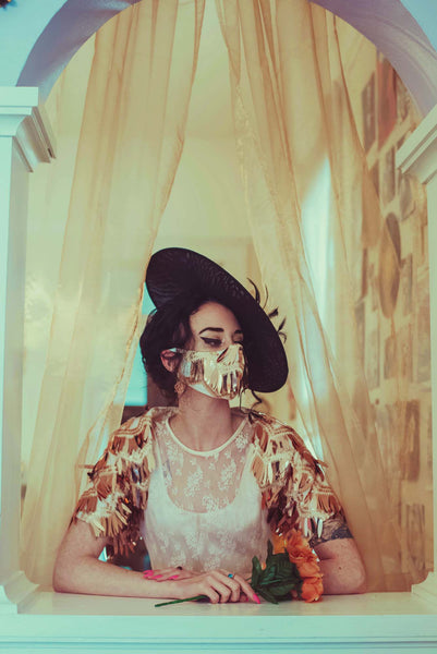 The Leslie Courreges Eleanor Mask features gold sequins against blush embroidery with rose gold fringe sequins.