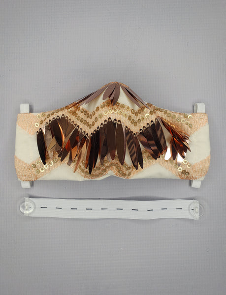 The Leslie Courreges Eleanor Mask features gold sequins against blush embroidery with rose gold fringe sequins.